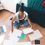 Femme en pleine réflexion pendant un bilan de compétences, avec tests de personnalité MBTI et STRONG sur la table