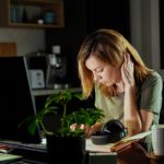 Femme en réflexion devant son ordinateur, envisageant une reconversion professionnelle à 40 ans.