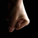 a close up of a person's Poing serré en signe de résistance ou de colère, illustrant la lutte intérieure face au changement.