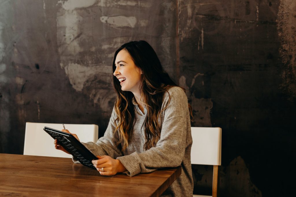 Femme souriante en posture professionnelle, en discussion dans un bureau, symbolisant la clarté et la confiance après une transition de carrière.