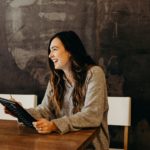 Femme souriante en posture professionnelle, en discussion dans un bureau, symbolisant la clarté et la confiance après une transition de carrière.