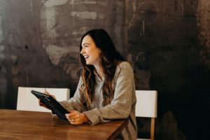 Femme souriante en posture professionnelle, en discussion dans un bureau, symbolisant la clarté et la confiance après une transition de carrière.