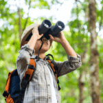 Enfant regardant à travers des jumelles dans une forêt pour illustrer un test de motivations professionnelles